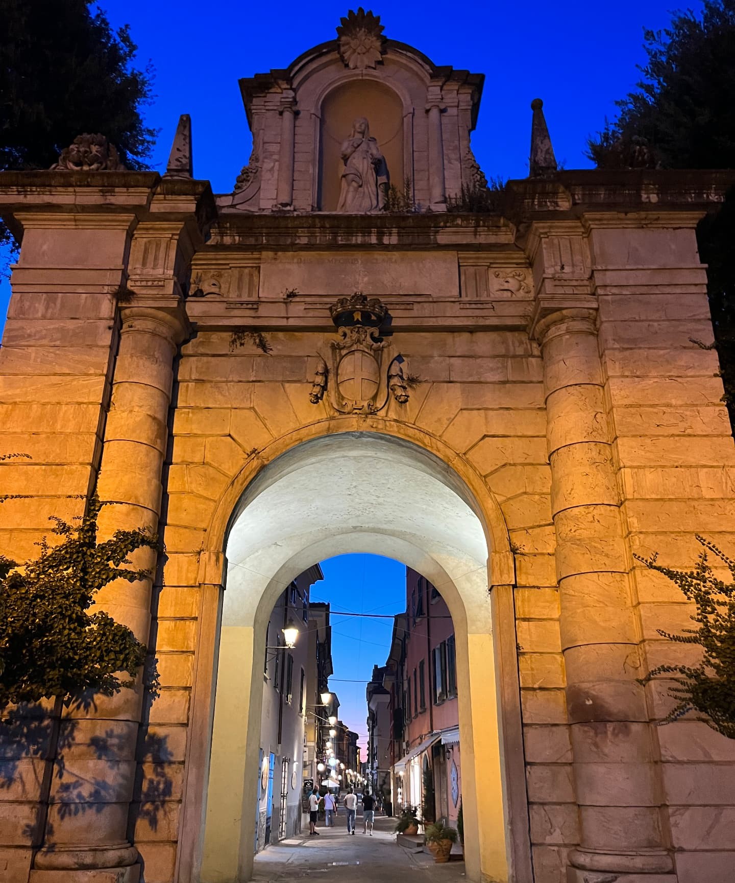 A historic town gate lit up at dusk
