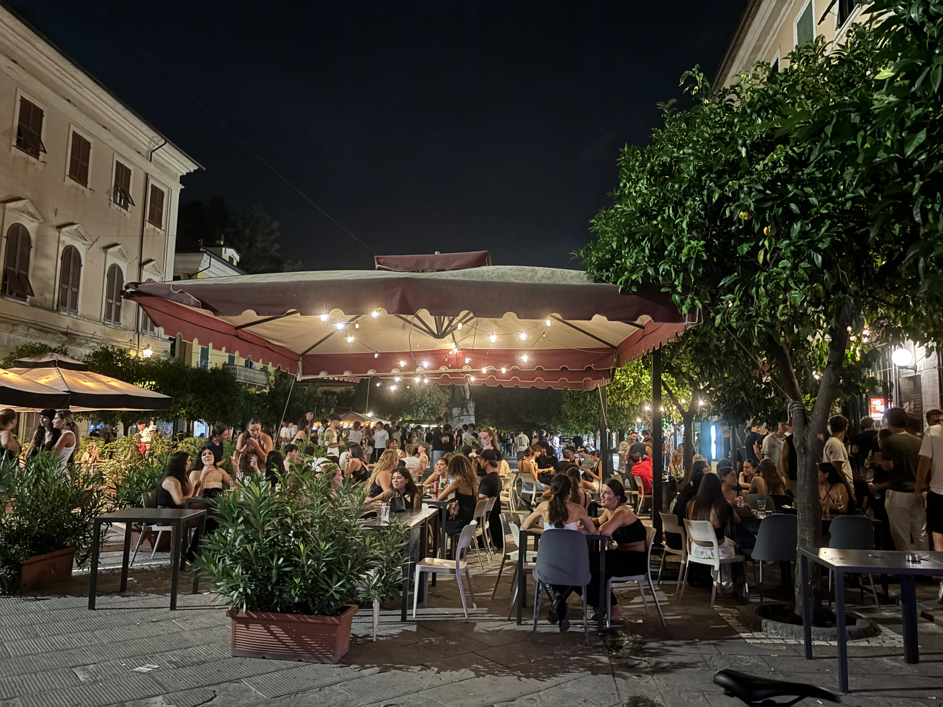 An outdoor café square full of people at night