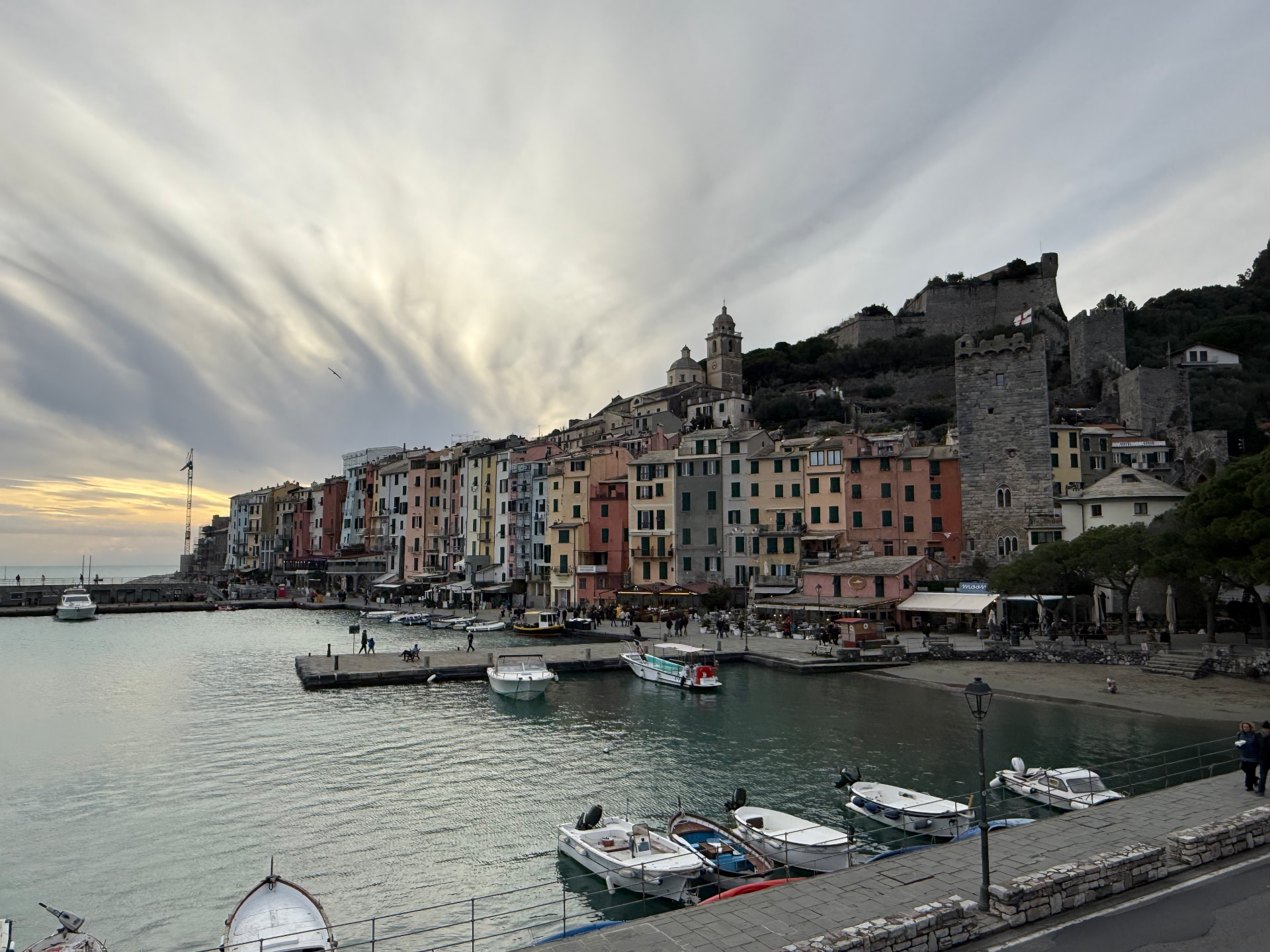 The harbour of Porto Venere at dusk, boats moored below colourful houses